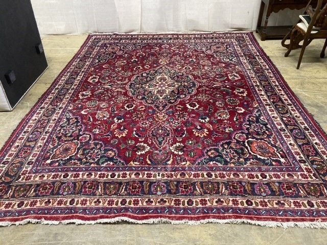 A Heriz style burgundy ground carpet, 380 x 360cm